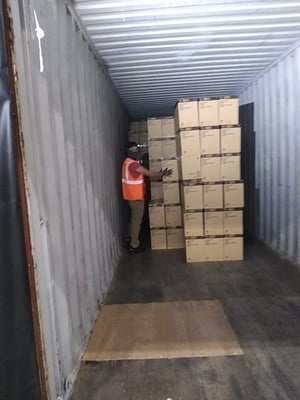 Team member stocking boxes inside of a storage container.